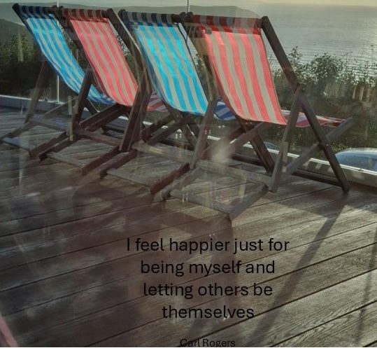 Deck chairs A photo of four deck chairs on a pier looking out to sea, with an inspirational quote from Carl Rogers